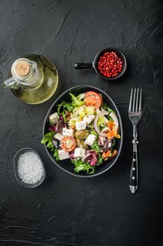 Greek salad with fresh vegetables, feta cheese and olives kalamati, on black background, top view flat lay