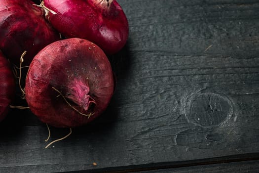 Purple Onion, on black wooden table background with copy space for text