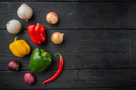 Collection of vegetables Bell pepper and onion, on black wooden table background, top view flat lay with copy space for text
