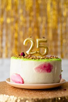 Birthday party. Golden candles 25 on birthday cake on golden glitter background