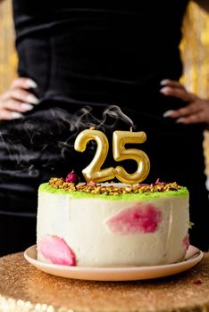 Birthday party. Woman in black party dress ready to eat birthday cake celebrating her twenty fifth birthday