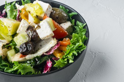 Traditional greek salad with fresh vegetables, feta and olive, on white background