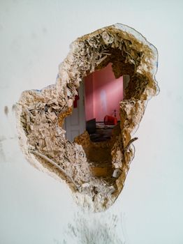 Small hole in thick wooden wall of old tenement house