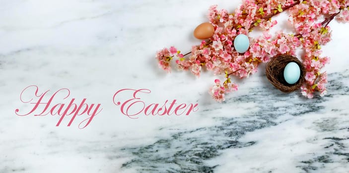 Happy Easter concept with springtime cherry blossoms and small bird nest with one egg inside on stone background in flat lay format plus text message