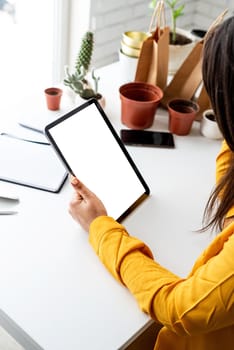 Home gardening. Mock up design. Woman gardener hands holding digital tablet with blank screen