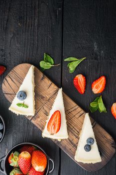 Slices Of Classical New York Cheesecake, on black wooden table background, top view flat lay with copy space for text