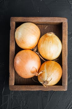 Organic onions, on black background, top view flat lay