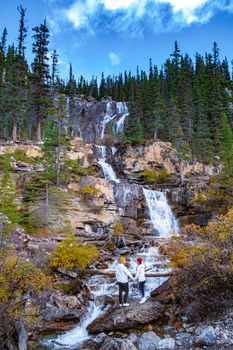 Tangle Creek Falls in Jasper National Park, Alberta, Canada, couple men and woman mid age hiking up to waterfall in nature . Banff national park