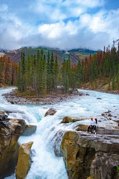 Beautiful view of Sunwapta Falls Jasper National Park, Canada. Canadian Rockies, ouple men and woman visit Sunwapta Falls Jasper