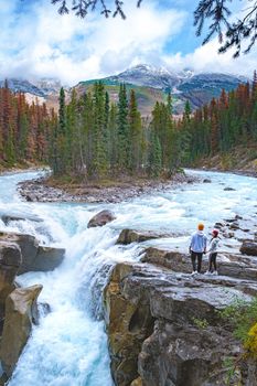 Beautiful view of Sunwapta Falls Jasper National Park, Canada. Canadian Rockies, ouple men and woman visit Sunwapta Falls Jasper