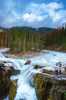 Beautiful view of Sunwapta Falls Jasper National Park, Canada. Canadian Rockies, ouple men and woman visit Sunwapta Falls Jasper