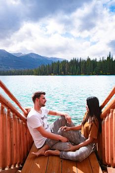 Beauvert lake at Jasper, Canada, Canadian lake popular for canoe. in the Canadian Rockies Jasper national park, couple men and woman mid age looking out over the lake