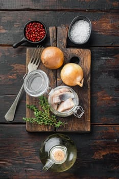 Sliced herring in oil marinated, on old dark wooden table background, top view flat lay