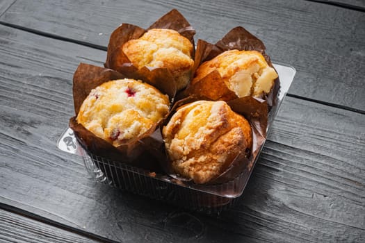 Freshly Baked Muffins in Container, on black wooden table background