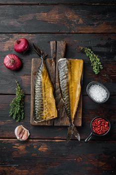 Whole smoked fish mackerel, on old dark wooden table background, top view flat lay
