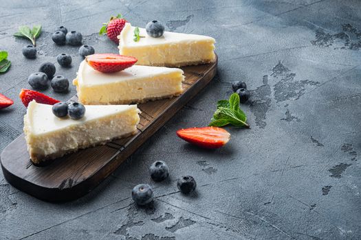 Cheesecake with blueberrie and strawberries, on gray background with copy space for text