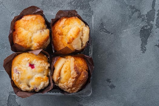 Muffins in plastic container, on gray background, top view flat lay with copy space for text