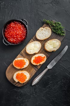 Canape with Red Salmon Caviar, for New Year, on black background, top view flat lay