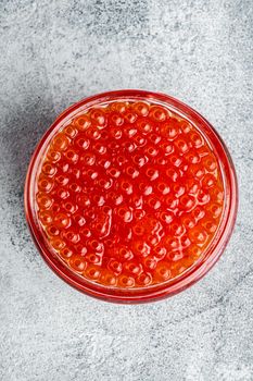 Red caviar jar, on gray background, top view flat lay