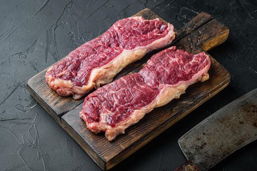 Sliced raw piece of marble beef steak, on black background
