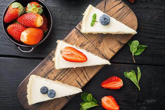 New York cheesecake or classic cheesecake with fresh berrie, on black wooden table background, top view flat lay