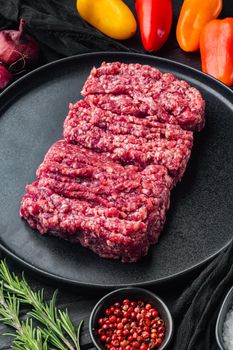 Mince. Ground meat with ingredients for cooking, on black wooden table background