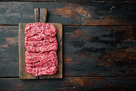 Fresh, minced meat ground beef, on old dark wooden table background, top view flat lay with copy space for text