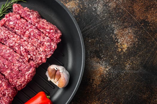 Fresh raw minced beef, ground meat, on old dark rustic background, top view flat lay with copy space for text
