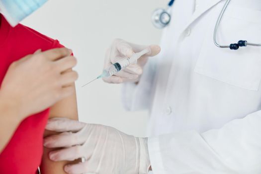 doctor injecting an injection into the shoulder coronavirus vaccination close-up. High quality photo