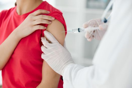 a doctor injects a vaccine into the shoulder of a woman patient close-up. High quality photo