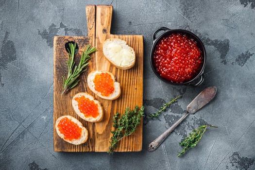 Canape with Red Salmon Caviar, for New Year, on gray background, top view flat lay