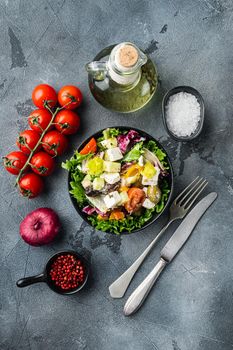 Greek salad with feta cheese and organic fresh olives, on gray background, top view flat lay