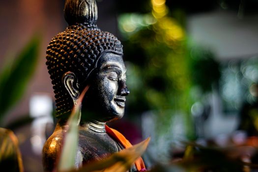 buddha statue in interior garden at tropical bar in bangkok thailand