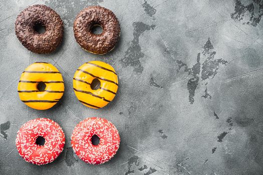 Various decorated, doughnuts, on gray background, top view flat lay with copy space for text