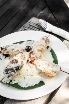 tropoical fish skewers with creamy coconut sauce and rice in vietnam restaurant