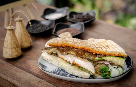 vegan roasted vegetable toasted panini sandwich in rustic garden table setting outdoors in sicily