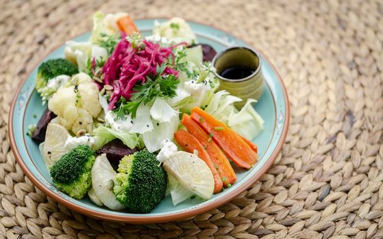 rustic cottage salad with healthy mixed steamed and fresh vegetables on colorful plate