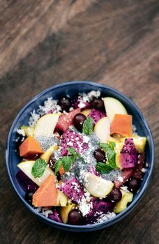 exotic mixed tropical asian fruit salad with basil seeds and coconut in bowl outdoors