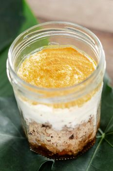 granola, coconut mousse, dates and turmeric powder healthy vegan dessert in rustic outdoors setting