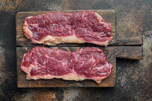 New york beef steaks, on old dark rustic background, top view flat lay