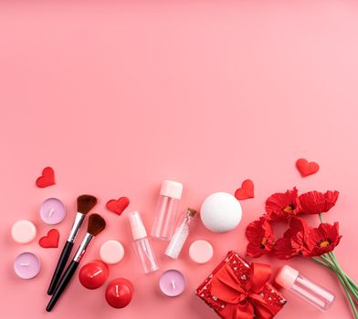 Valentines Day and Womens Day concept. Fashion cosmetic accessories with gift box, empty tubes and bottles, candles and confetti top view flat lay on pink background with copy space