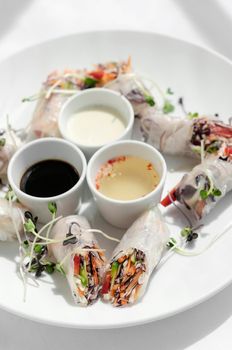 asian fresh vegetable vegan spring rolls with sauces in vietnam