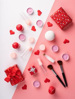 Valentines Day and Womens Day concept. Fashion cosmetic accessories with gift box, flowers, empty tubes and bottles, candles and confetti top view flat lay on double pink and white background