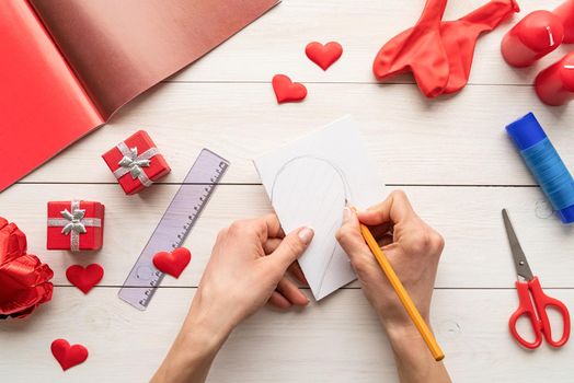 Valentines Day craft DIY. Step by step instruction making paper heart shape hot air balloon. Step 1 - fold paper and draw a half of a heart