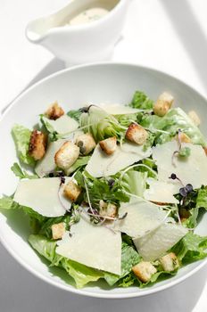 caesar salad with parmesan cheese and croutons on restaurant table