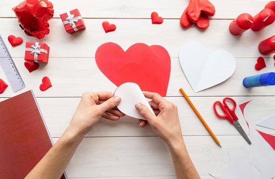 Valentines Day craft DIY. Step by step instruction making paper heart shape hot air balloon. Step 4 - fold every heart into halves