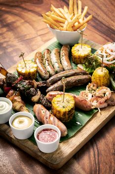 organic mixed grill barbecue meat platter rustic set meal with sausages, skewers, side dishes and sauces