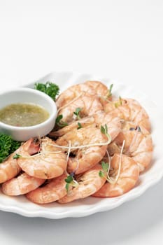 fresh boiled prawns with zesty citrus dipping sauce on white background