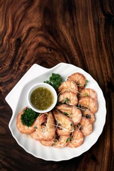 fresh boiled prawns with zesty citrus dipping sauce on wood table
