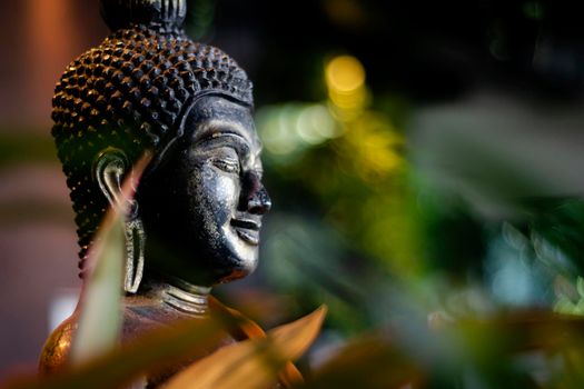 buddha statue in interior garden at tropical bar in bangkok thailand